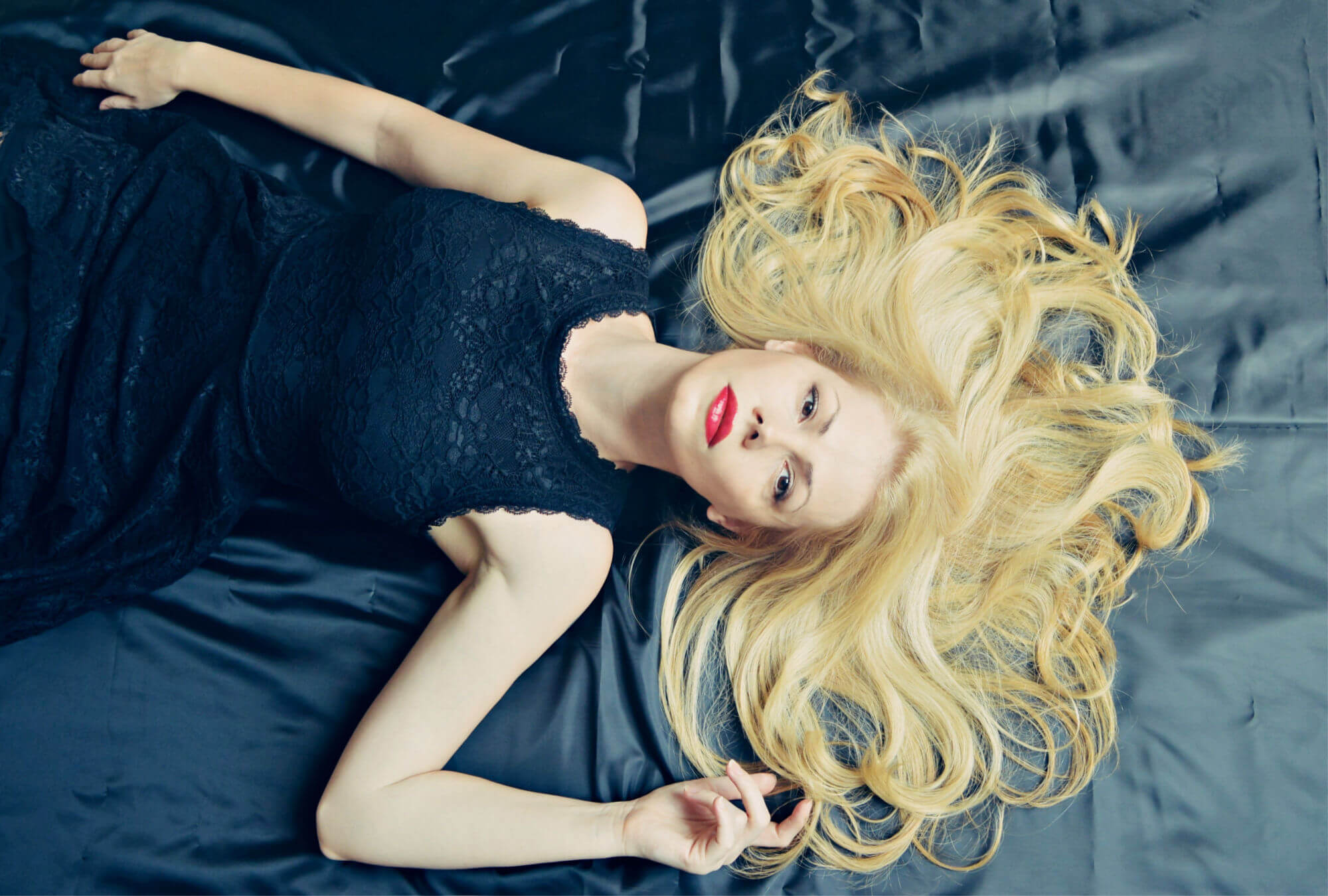 blonde laying down in black dress