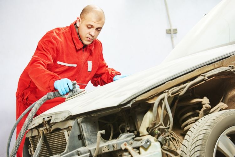 man sanding a car bonnet